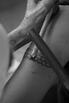 a woman with a tattoo on her arm holding a knife and looking at the camera