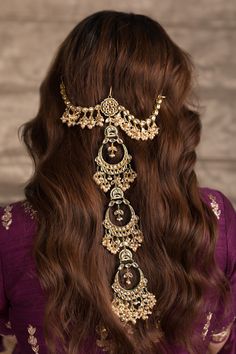 the back of a woman's head wearing gold jewelry