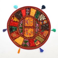 a decorative round rug with tassels on the edges and fringes around it