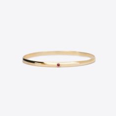 The Milestone bangle with the addition of one bezel set birthstone. A beautiful piece to add to your stack for a celebration or to represent children or grandchildren. A 4mm solid 14k gold half round bangle with a flat interior.Stone Details: 2.5mm natural birthstones totaling approximately .1tcw The stones in our jewelry are always natural/earth mined, with the exception of Alexandrite, which is lab grown. We source lab grown Alexandrite to ensure high quality and consistent and fair pricing. T Classic Gemstone Bangle For Anniversary, 14k Gold Bangle With Single Diamond For Fine Jewelry, Fine Jewelry Bangle With Single Diamond, 14k Gold Stackable Bracelets With Round Band, Stackable 14k Gold Bracelet With Round Band, Stackable 14k Gold Bracelets With Round Band, 14k Gold Wedding Bangle With Single Diamond, Dainty 14k Gold Stackable Bangle, Stackable Dainty 14k Gold Bangle