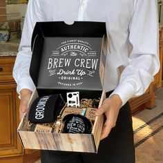 a man is holding a beer box in his hands and wearing a white button up shirt