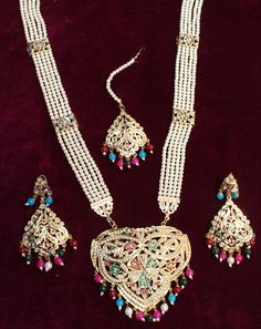 Jadau navrattan Rani Haar necklace Set embellished with pearls. Necklace length: 13 inches (including pendant) Earrings length: 2.9 inches (with drops) ; Width: 1.3 inches Multicolor Bridal Necklace With Latkans For Puja, Traditional White Necklaces For Eid, Festive Multicolor Bridal Necklace With Latkans, Multicolor Kundan Necklace For Puja In Bollywood Style, Multicolor Kundan Necklace With Latkans For Festivals, Traditional Multicolor Kundan Necklace With Latkans, Traditional Multicolor Kundan Necklace For Festive Occasions, Multicolor Bridal Necklace With Latkans For Festivals, Traditional White Kundan Necklace For Eid