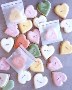 some heart shaped cookies are on a table and one has a piece of paper with the words i love you