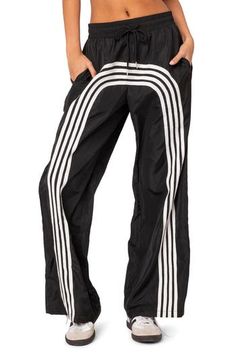 Sporty stripes race around the wide legs of these tie-waist track pants. Elastic/drawstring waist Side pockets 100% polyester Machine wash, dry flat Imported White Sporty Pants With Contrast Stripes, Summer Sports Wide-leg Parachute Pants, Sporty White Pants With Contrast Stripes, Sporty Striped Bottoms With Pockets, Sporty Spring Pants With Contrast Stripes, Athleisure Pants With Contrast Stripes For Spring, Sporty Striped Pants With Side Stripes, Sporty Wide Leg Bottoms With Contrast Stripes, Casual Bottoms With Signature Stripes For Streetwear