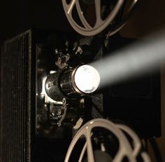 a close up view of an old movie projector with light coming through the lens