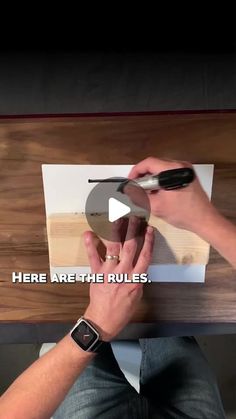 a person holding a pen and pointing at a piece of paper with the words here are the rules