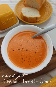 a bowl of tomato soup with bread on the side