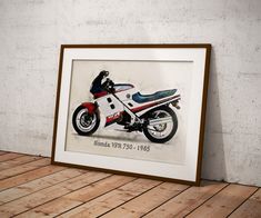 a framed photograph of a motorcycle on a wooden floor