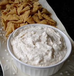 a bowl of dip and chips on a plate