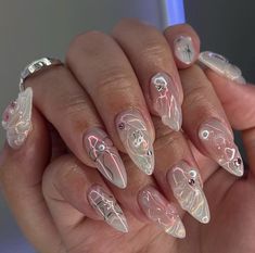 a woman's hand with some white and pink nail art