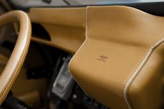 the interior of a car with tan leather and white stitching on the steering wheel