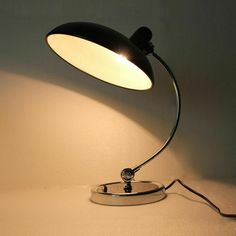 a lamp that is sitting on top of a white surface with the light turned on