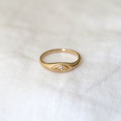 eye is delicately embossed on the front of a thin oval signet ring, with a single white diamond in the center Signet Rings Women Vintage, Oval Signet Ring, Diamond Face, Signet Rings, Matte Gold, Signet Ring, Free Giveaway, Jewelry Care, White Diamond