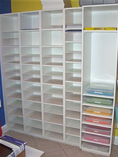 a large white book shelf filled with lots of books next to a blue and yellow wall