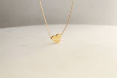 "Add a touch of elegance and sophistication to your jewelry collection with this beautiful brushed heart pendant necklace. Made with 18k gold dipping, this necklace features a unique and striking heart charm with a brushed finish that gives it a beautiful, soft texture. The heart is a symbol of love, affection, and connection, making this necklace a great gift for yourself or a loved one. The 16 inch chain is delicate and understated, allowing the heart charm to be the focal point of the piece. Minimalist Heart Charm Jewelry, Minimalist Jewelry With Heart Charm, Minimalist Heart Jewelry With Simple Design, Minimalist Heart Shaped Jewelry With Simple Design, Minimalist Heart-shaped Jewelry With Simple Design, Minimalist Silver Heart Necklace In 14k Gold, Gold Heart-shaped Jewelry For Bridesmaid Gift, Gold Heart Shaped Jewelry For Bridesmaid Gift, Gold Heart Jewelry For Bridesmaid Gift