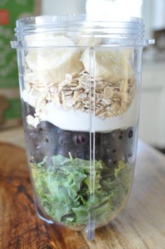 a blender filled with lots of different types of food on top of a wooden table