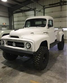 an old white truck parked in a garage