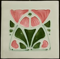 a white and green tile with pink flowers on it's side, in the shape of a flower