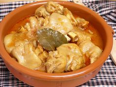 a brown bowl filled with food on top of a checkered table cloth