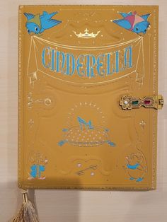 a yellow binder with blue birds on it and the word cinderella written in gold