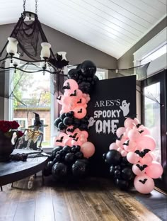 balloons are arranged on the floor in front of a black and white sign that reads area's spooky one