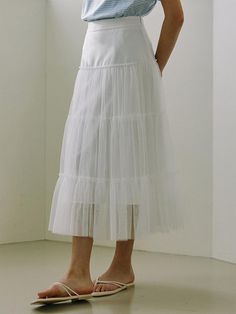 This product is a tulle layered long skirt that exudes a dreamy and ethereal quality. It features multiple layers of tulle that create a voluminous and flowing silhouette. The skirt is designed to sit at the waist, with a smooth waistband that transitions into soft, gathered tulle, offering both comfort and a flattering fit. - The skirt's multiple tulle layers add a romantic and fairy-tale like dimension to any outfit.- Its long, flowing design allows for graceful movement and an elegant appearance.- The fitted waistband ensures the skirt sits comfortably at the waist, accentuating the wearer's natural shape.- This tulle skirt is a versatile piece that can be styled up for a formal event or paired down for a casual, whimsical look. Elegant Midi Tulle Skirt, Elegant Tulle Midi Skirt, Elegant Flared Tulle Skirt, Elegant Tulle Tiered Skirt Petticoat, Elegant Tiered Tulle Petticoat, Elegant Voluminous Tulle Petticoat, Flowy Tiered Tulle Maxi Skirt, Feminine Flowy Tulle Skirt, Tiered Tulle Maxi Skirt With Lining