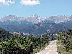 an empty road with mountains in the background