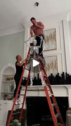 two men working on a fire place in a living room