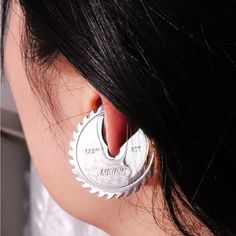 a close up of a person wearing a pair of earrings