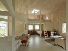 a living room filled with furniture next to a loft type building that's made out of plywood