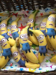 bunches of bananas with minion faces on them in a wicker basket filled with stars