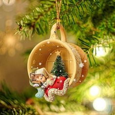 a christmas ornament hanging from a tree with a dog in it's sleigh