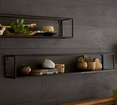 two shelves with plants and other decorative items on them in a room that has dark wood paneling