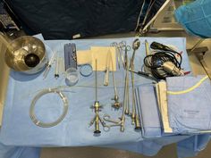 an assortment of medical equipment sitting on a blue tablecloth in a hospital room with other items