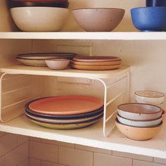 bowls and plates on shelves in a kitchen