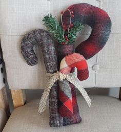 a christmas decoration sitting on top of a chair next to a candy cane and wreath