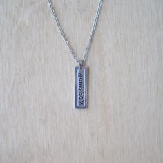 a silver necklace with the word love is written on it