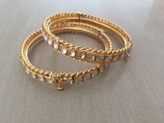 *This is Gold Finish Kundan Bangles pair.Its Perfect for Wedding Occasion as well as Unique and Ethnic Traditional Bangle to gift and Also Bridal wear to match with Wedding Outfits. *Its made from Silver n Copper mix material and 100% Handmade. *Its available in Various Sizes like 2,2.2,2.4,2.6 Etc Its white kundan combination like shown in picture. *Its open able Screwed Bangles Pair. *All Kundan stones set with silver foils handsetting method and long last guarantee of its workmanship.It is Wh Bollywood Style Bracelets With Intricate Design For Receptions, Stone Work Bracelets For Diwali Reception, Bollywood Style Bracelets For Reception With Intricate Design, Stone Work Bracelets For Reception And Diwali, Bollywood Style Intricate Bracelets For Reception, Temple Jewelry Bangle With Stone Work For Reception, Traditional Meenakari Bracelets For Reception, Traditional Heavy Bangle For Reception, Traditional Festive Bracelets For Reception