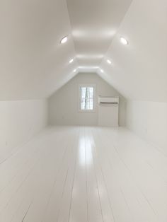 an empty room with white walls and floors