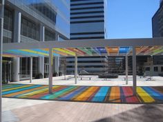 an artisticly painted walkway in the middle of a large city square with tall buildings behind it