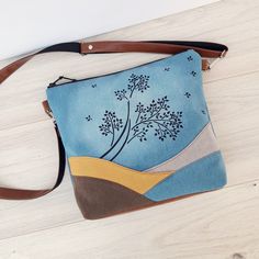 „ Aspen Tree" - print with Moon effect. Large or Medium crossbody bag. Front colors: Turquoise Blue, Yellow, Brown, Beige Back Color: Turquoise Blue Leather: Brown NOTE: Colors may vary on your screen. Approximate dimensions: LARGE bag: Width: 13 ½" (34cm) Height: 11" (28cm) Bottom: 3" ( 8cm ) Strap length approx. 25"/62,5cm/- about 48"/120cm/ MEDIUM bag: Width: 11 ½" / 29cm / Height: 9 ½" / 24cm / Bottom: 2 ½"/ 6,5cm / Strap length approx. 25"/62,5cm/ - about 48"/120cm/ Please write in NOTE if you would like another length - up to 58" only. - Lightweight sturdy bag. - Bag with three inside pockets. - In the inner pocket of the bag fits iPhone +. - Roomy enough to carry all the essentials. - It can be worn on any outfit. - Hand painted bag - Silver colored hardware Comfortable bag - fabric Blue Rectangular Shoulder Bag With Zipper Pouch, Blue Shoulder Bag With Zipper Pouch As Gift, Handmade Turquoise Shoulder Bag For Everyday, Turquoise Everyday Pouch Shoulder Bag, Turquoise Pouch Bag For Everyday, Blue Crossbody Shoulder Bag With Zipper Pouch, Moon Effect, Brown Note, Aspen Tree