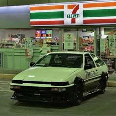 a white car parked in front of a 7 eleven convenience store