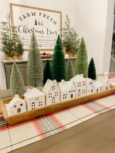 christmas trees are arranged on a tray in front of a table with a red and white checkered tablecloth