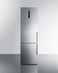 a metallic refrigerator freezer sitting in the middle of a room with an empty wall behind it