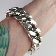 Super thick sturdy heavy sterling links flow around this vintage Mexican bracelet. The bracelet is constructed with 15/16 inch x 3/4 inch links that have a 9.2mm (3/8 inch) thickness. The heavy links have flat edges and conform to the wrist nicely. The bracelet closes with a long and wide curved box clasp topped by a push-bar button. The hefty bracelet contains over 200 grams of sterling silver. The 3/4 inch wide bracelet has an inner circumference of approx. 6 1/2 inches. The back is stamped, "Mexico, IA-20" and hallmarked, "925" (sterling silver). The links and hardware also tested as sterling silver purity.  This piece is in wonderful condition for its heavy weight, with expected minor surface wear and patina. Please see photos for condition and below for detailed measurements. Wt: 213. Modern Silver Cuban Link Bracelet With Chunky Chain, Classic Silver Cuban Link Bracelet With Chunky Chain, Silver Cuban Link Bracelet With Chunky Chain, Classic Silver Chunky Jewelry, Silver Chunky Classic Jewelry, Classic Chunky Silver Jewelry, Modern Silver Chunky Chain Bracelet, Chunky Silver Metal Chain Bracelet, Modern Chunky Silver Bracelet