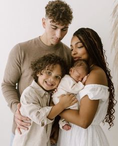 a man, woman and child are posing for a family photo with their newborn baby