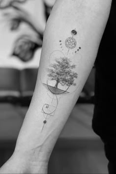 a person with a tattoo on their arm holding onto a tree and some other things