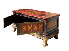 an ornately decorated wooden desk with drawers on it's sides and one drawer open