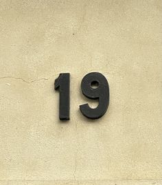 the number 19 is written in black on a stucco wall