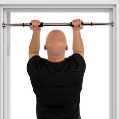 a man is doing pull ups in front of an open window with bars on both sides